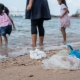 Mädchen, die am Strand im Plastikmüll spielen